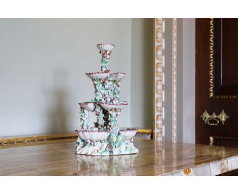 A Bow porcelain four-tiered sweetmeat stand, c.1755, with ten shells arranged on pillars of shell-encrusted and polychrome ro