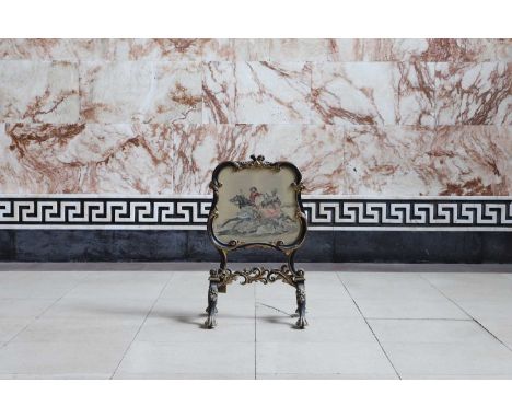 A Victorian carved, gilt and ebonised fire screen, the embroidered panel within a scrolling cartouche-shaped frame, over scro