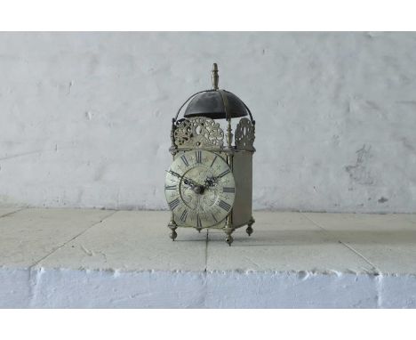 A 17th-century-style brass striking lantern clock, c.1900, surmounted by a large bell above an engraved and pierced frieze of