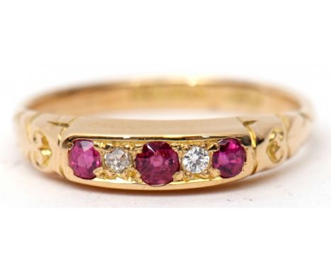 18ct gold ruby and diamond ring, alternate set with three graduated circular cut rubies and two small diamonds, all in a carv