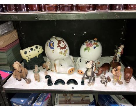 A shelf of animals ornaments including a large piggy bank and a cast iron door stop