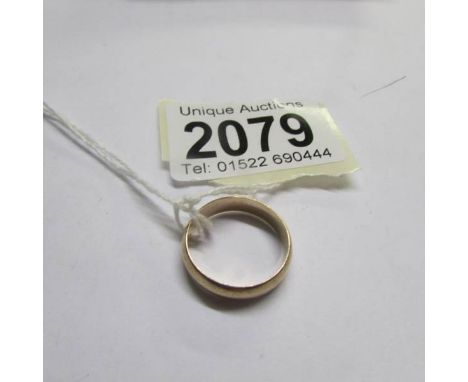 An unmarked 9ct gold wedding ring, size M (with receipt for remodelling 2 9ct gold rings in to one).