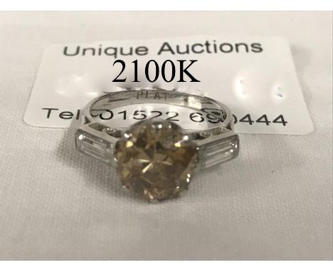 A fine champagne diamond ring on platinum, approximately 2ct with diamond baguette shoulder .02 each
