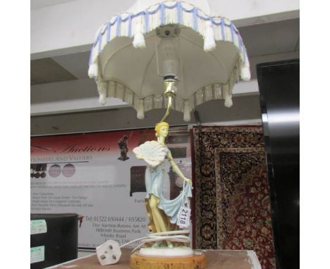 A figural style table lamp with shade.