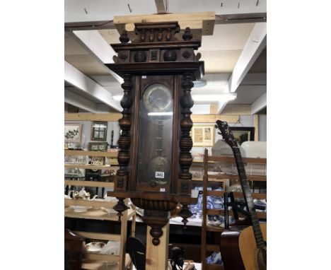 A Victorian wall clock with pendulum featuring portrait of lady and key
