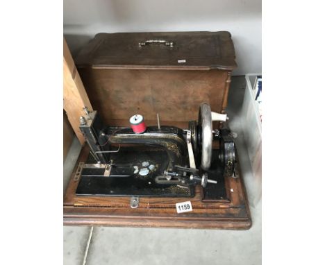 A vintage sewing machine inlaid with mother of pearl in an inlaid case