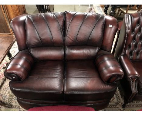 An oxblood 2 seater sofa