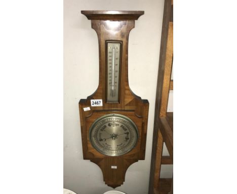 A wall barometer with thermometer