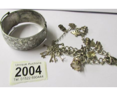 A silver charm bracelet and an Edwardian silver bangle (tested).