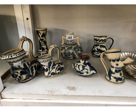 7 items of blue and white motto ware including jugs, vases and candlestick holder