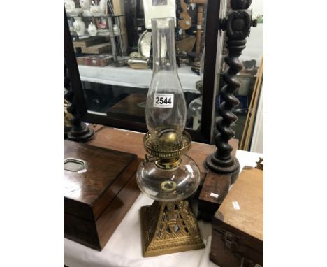 An oil lamp with metal stand, glass vessel and chimney