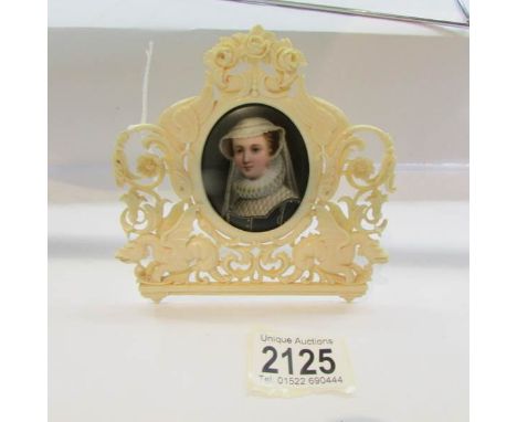 A hand painted 19th century miniature portrait on porcelain (chip to edge) in a decorative 19th century ivory frame.