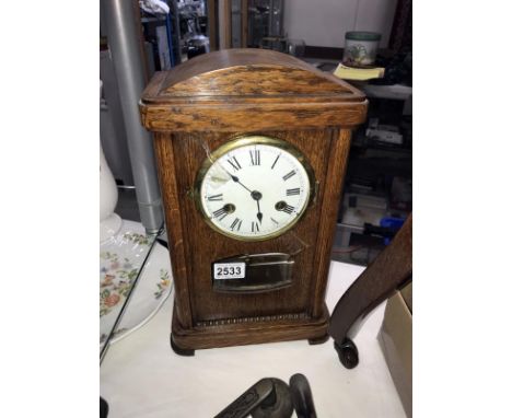 An oak case mantel clock with pendulum