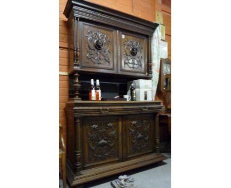 A 19th Century Carved Walnut Side Cabinet, with upper section having two cupboards, each with central relief bust, above a sh