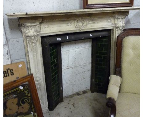 A Victorian Cream Painted Metal Fire-Surround with relief decoration, matching insert with green tiles.
