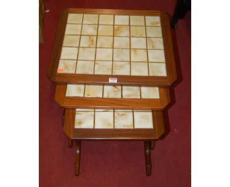 A 1960s G-Plan teak and tile-top nest of three occasional tables, the largest w.53cm