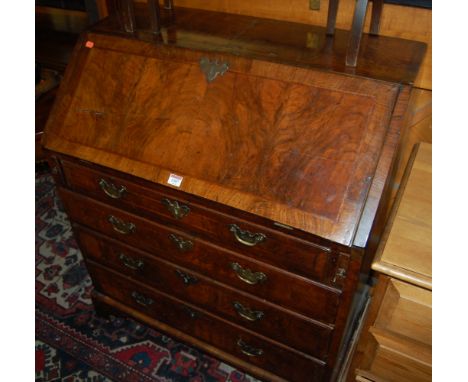 A mid 18th century figured walnut crossbanded and feather banded slopefront writing bureau, having a fitted interior over fou