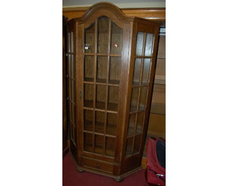 An oak single door glazed bookcase, of credence form, with single lower drawer, w.108cm