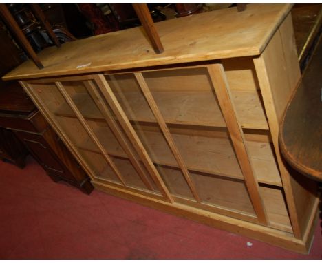 A modern pine double door glazed bookcase, having twin sliding doors, w.150cm