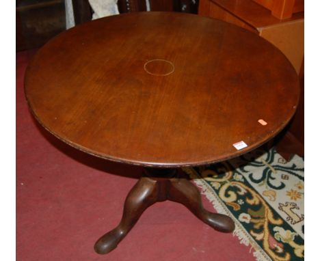 A George III mahogany circular tilt top pedestal tripod table, having a birdcage action, and on hipped supports, dia. 89cm