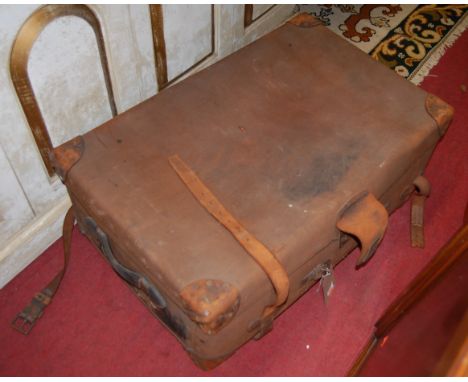An early 20th century canvas and tan leather bound travelling trunk having end carry handles, width 83cm