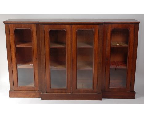 A Victorian mahogany breakfront bookcase by H Mawer & Stephenson Ltd of London, having four glazed doors enclosing shelved in