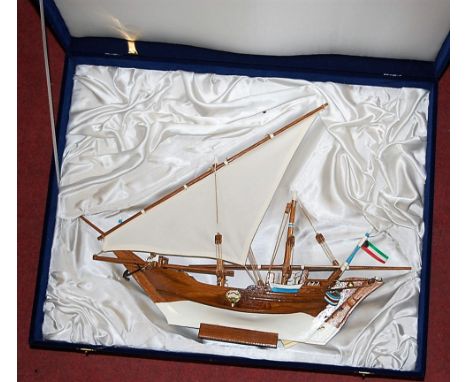 A velvet cased reproduction wooden model of a sailing boat
