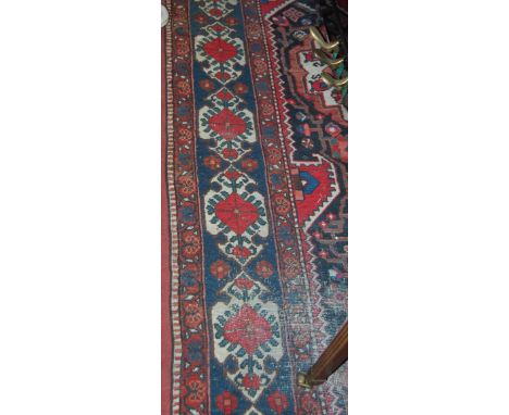 A Caucasian woollen carpet, the central ground with lozenge medallion, geometric motifs within trailing tramline borders (wor