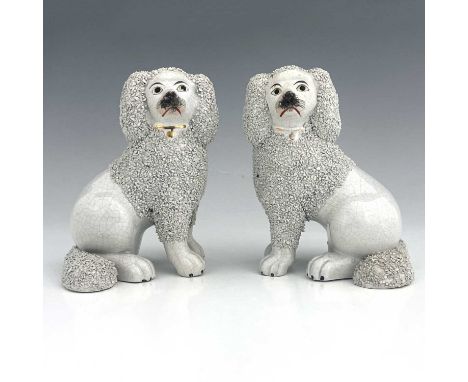 A Staffordshire matching pair of poodles, circa 1860, seated figures modelled as part-shaved poodles with granulated clay app