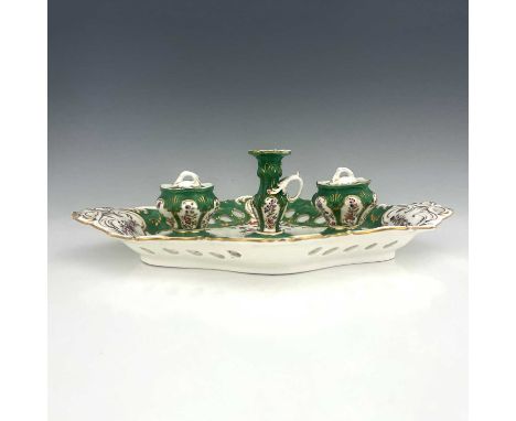 A Coalport desk stand, including a pair of inkwells and covers, and candlestick, painted with flowers within gilt and green b