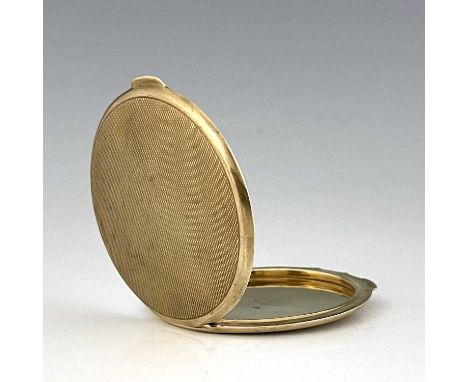 An Art Deco 9 carat gold compact, Goldsmiths and Silversmiths Company, London 1937, circular, engine turned design, 7cm diame