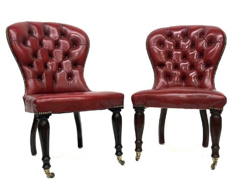 A pair of Victorian design gentleman's library balloon back chairs, brass studded button back red leather upholstery, serpent