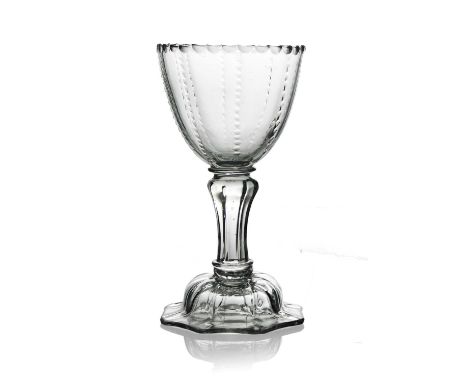 A pedestal sweetmeat glass or goblet, circa 1750, the rounded bowl with facet cut rim and cut vertical ribs, on an inverse fl