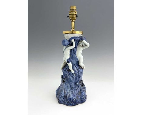 A Chinese blue and white figural lamp, modelled as two boys climbing a gnarled tree trunk, 40cm high
