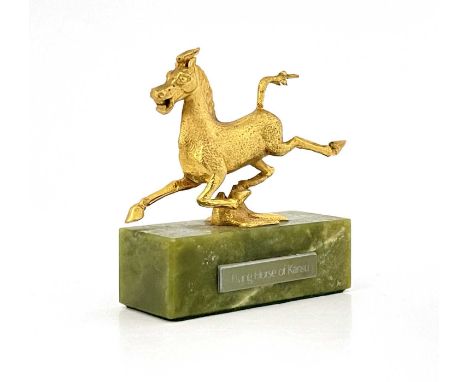 An Elizabeth II 9ct gold model of The Flying Horse of Kansu, limited edition No.8/100, London 1973, mounted on a bowenite pli