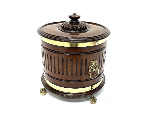 A late 19th Century cellarette, of drum form, turned cover with finial atop a gadroon craved dome, brass coopered chip-carved