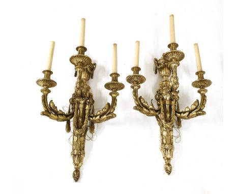 A pair of large decorative gilt brass three-light wall lights, each with swagged urn finials, over acanthus leaf decorated an