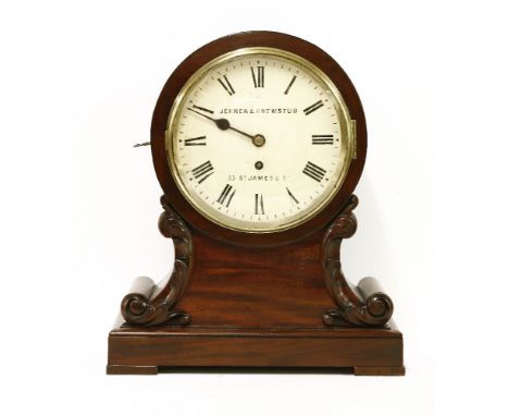 A mahogany cased drumhead bracket clock, mid-19th century, of typical form with carved scrolls and foliate designs to the out