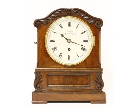 A mahogany cased bracket clock, 19th century, the shaped arched top with carved scrolls above stylised leaves, the body with 