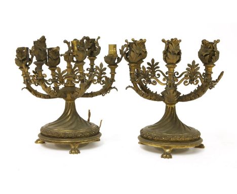 A pair of ormolu six-light table lamps, each with acanthus leaf sconces, arabesques and spiralled circular bases, and standin