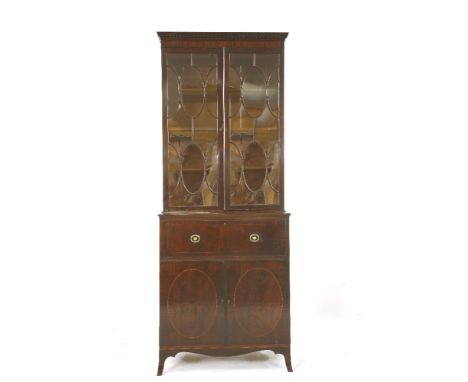 A George lll mahogany secretaire bookcase, in the manner of Gillows of Lancaster, the upper section with a dentil carved corn