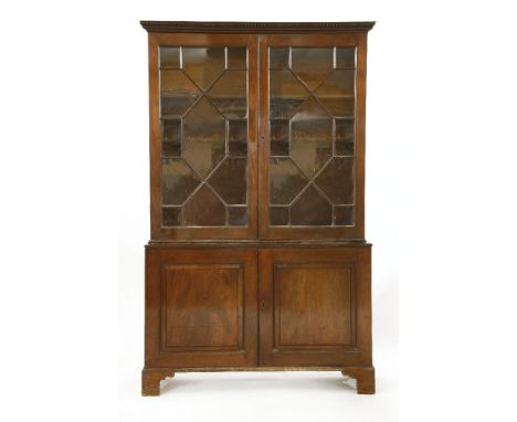 A George lll mahogany bookcase cabinet,the upper section with astragal glazed doors, opening to reveal adjustable shelves ove