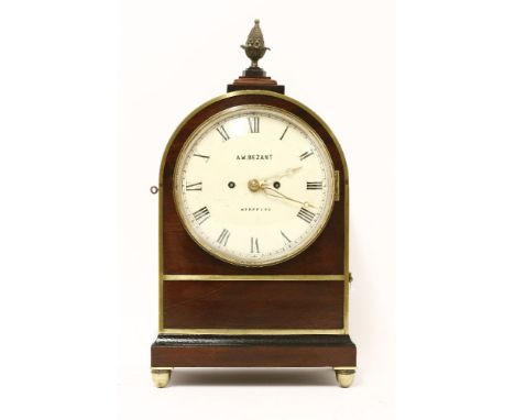 A brass-bound mahogany bracket clock, 19th century, the arched body surmounted by a pineapple finial with pierced brass fishs