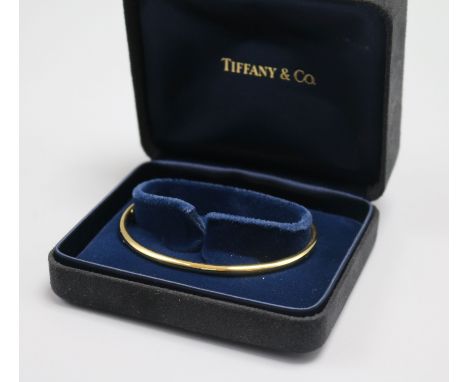 A Tiffany & Co 9ct gold bangle, with Tiffany & Co boxes.