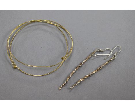 An 18ct gold bangle and a pair of parcel gilt silver spiral twist earrings.