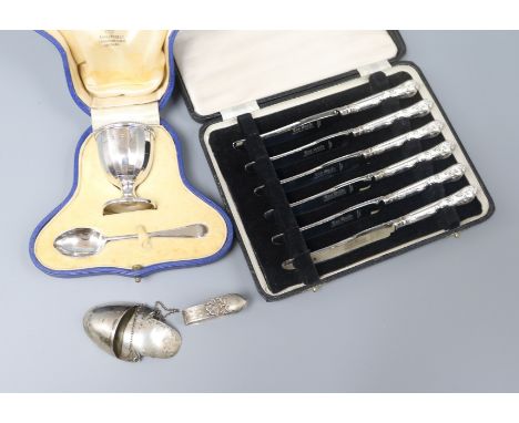 A cased silver christening spoon and egg cup, a cased set of tea knives and two other items.