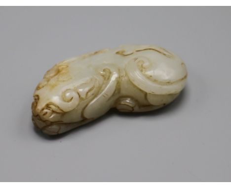A Chinese pale celadon and russet jade figure of a lion-dog, Qing dynasty