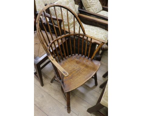 An early 19th century elm and ash stick back elbow chair