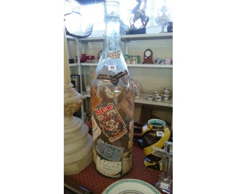 A large glass bottle decorated with various vintage wine bottle labels.