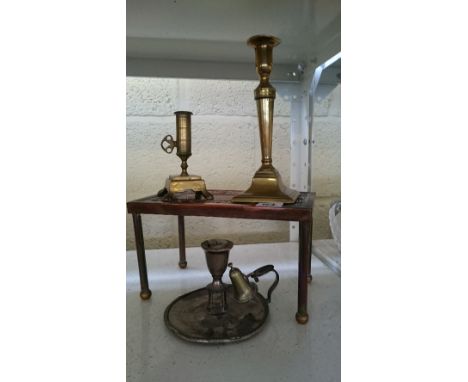 An Arts & Crafts style copper rectangular trivet together with two brass candlesticks and a silver plated chamber stick.